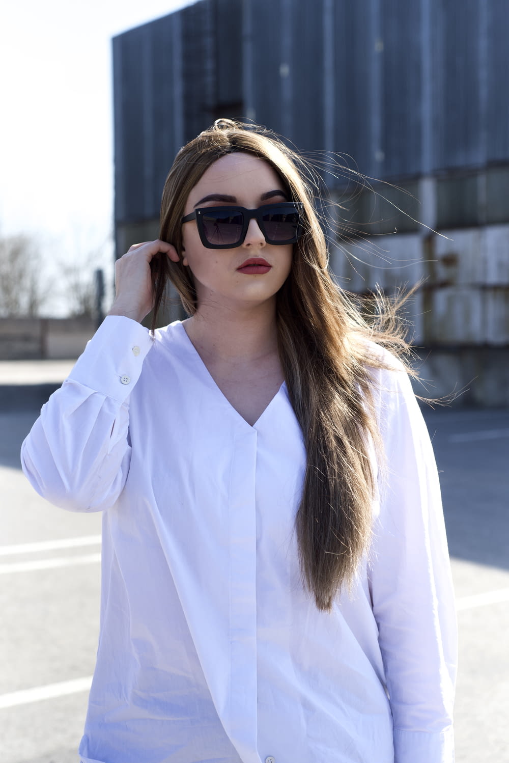 woman in white dress shirt wearing black sunglasses