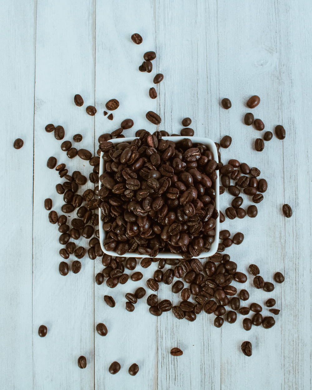 brown coffee beans on white wooden table