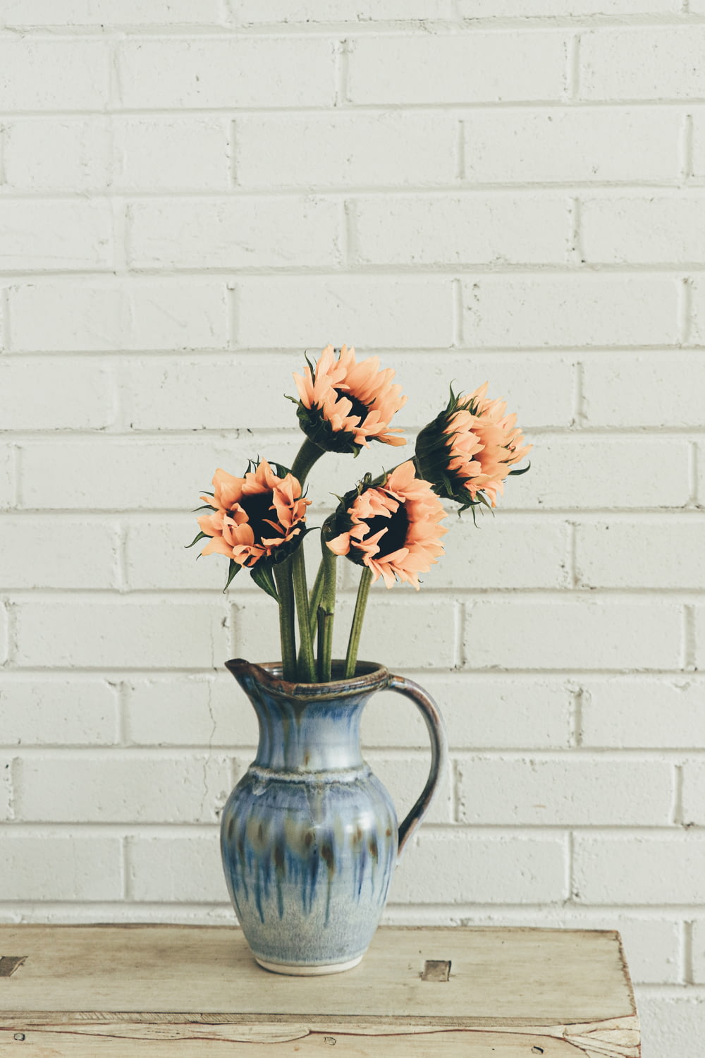orange flowers in blue ceramic vase