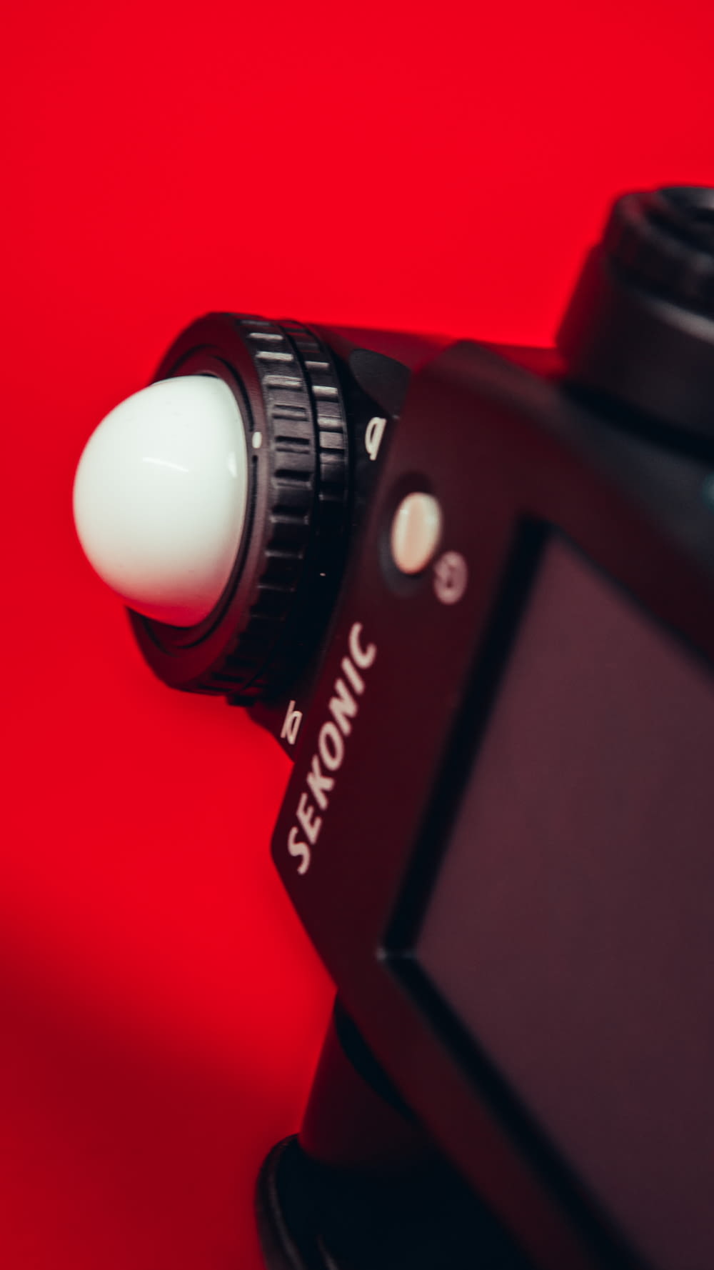 black canon dslr camera on red textile
