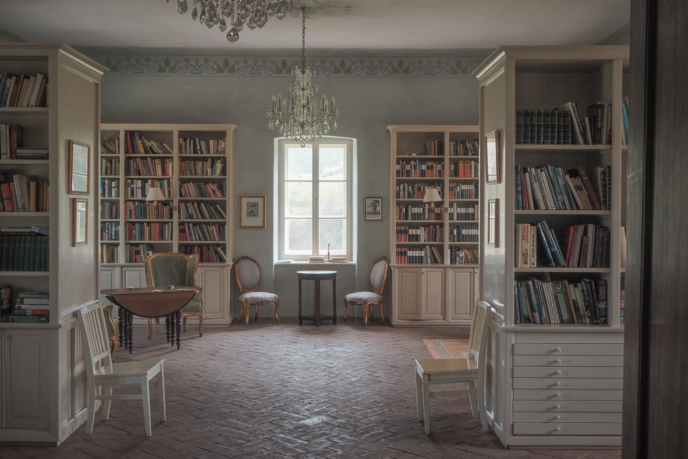 a room filled with lots of books and a chandelier