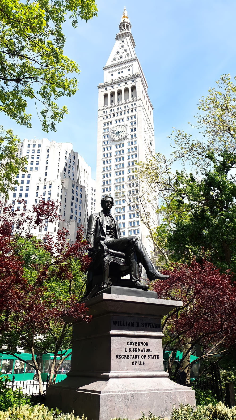man sitting statue near white concrete building during daytime