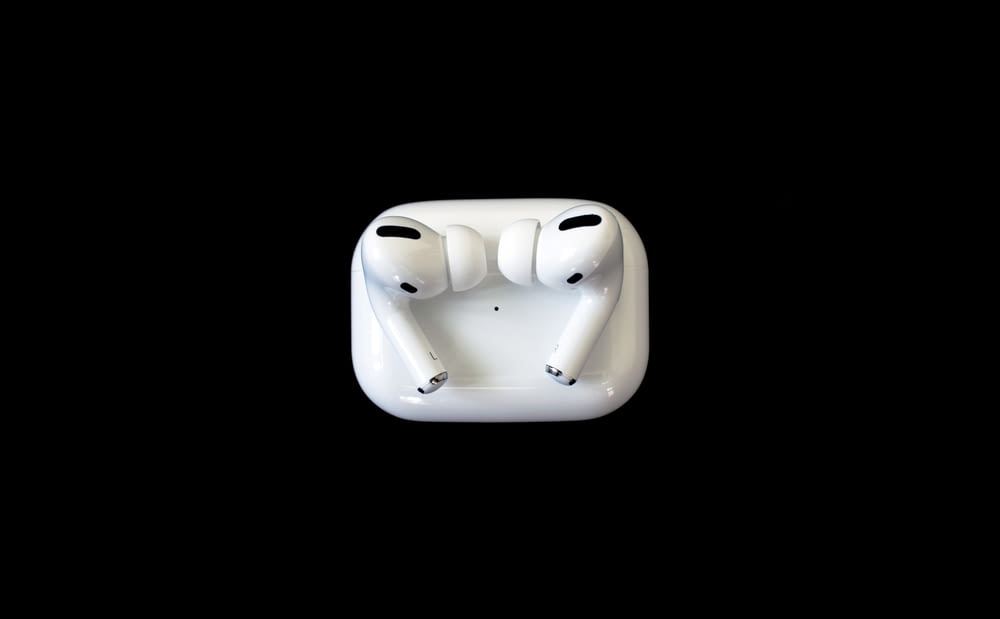 Auriculares de manzana blanca sobre superficie blanca