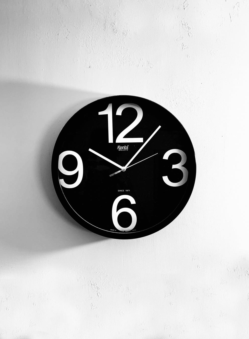 Horloge murale analogique noir et blanc à 10h00