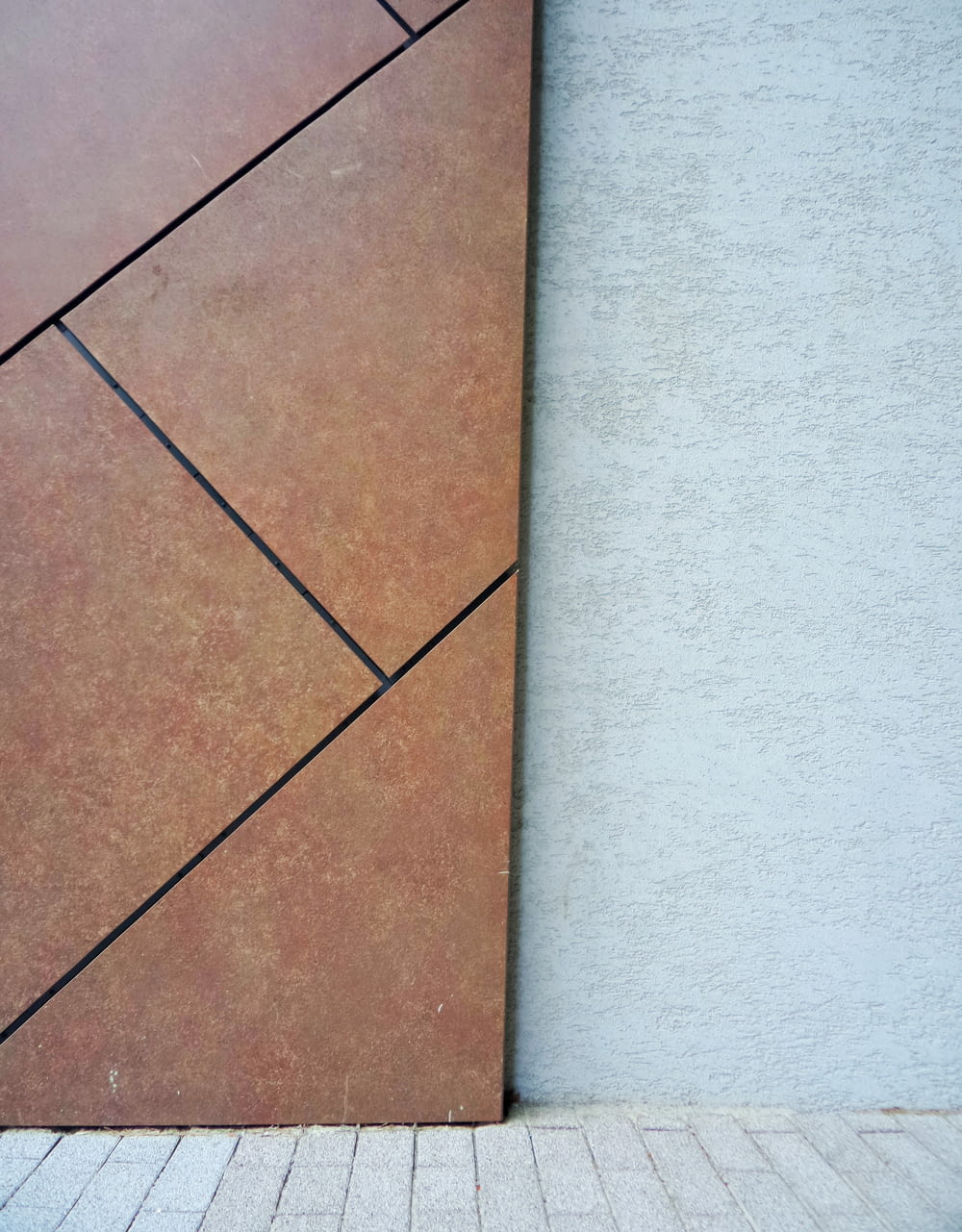 brown floor tiles beside green wall