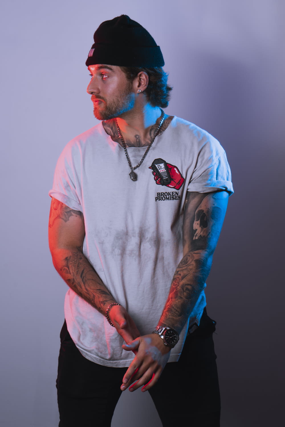 Hombre en camiseta blanca de cuello redondo con tatuaje azul y negro en el brazo derecho