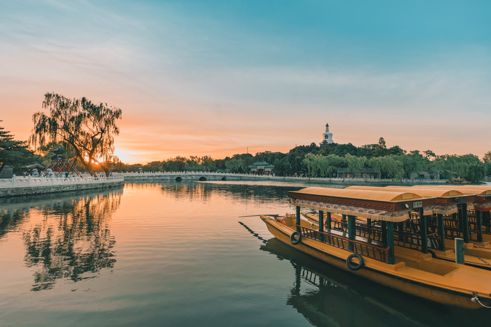brown boat on lake during sunset