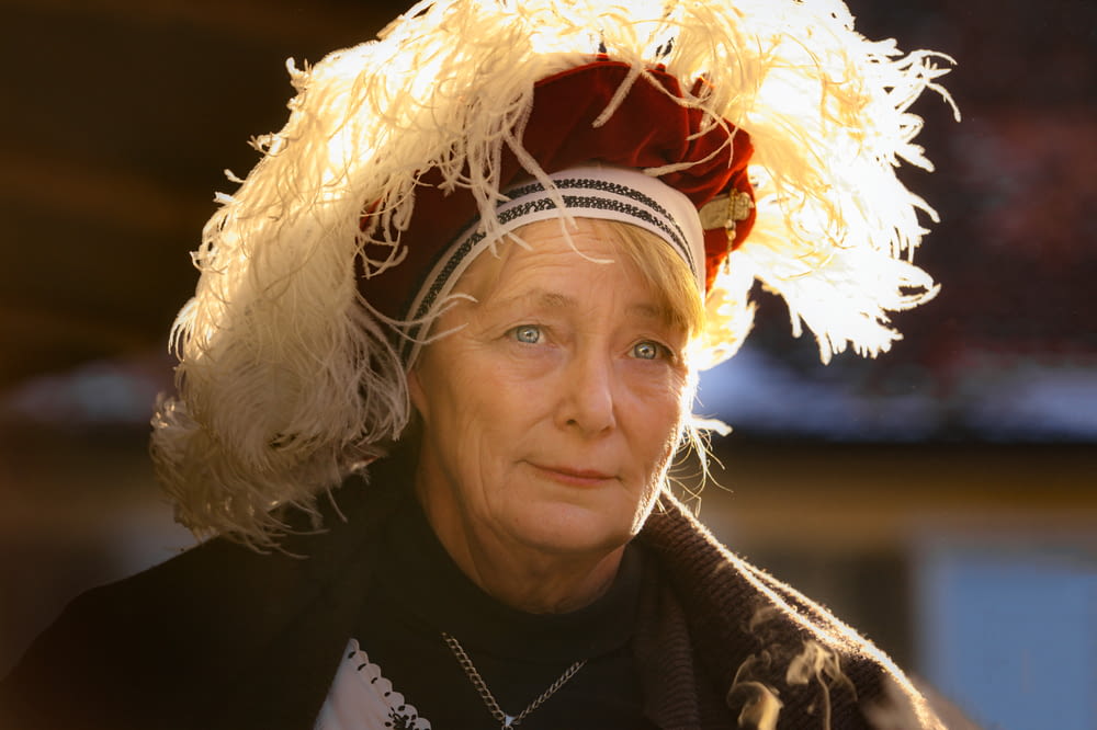 a woman wearing a hat with feathers on it