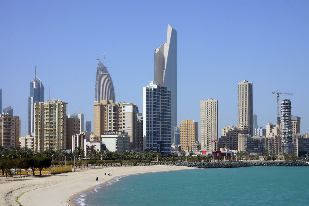 people on beach near high rise buildings during daytime