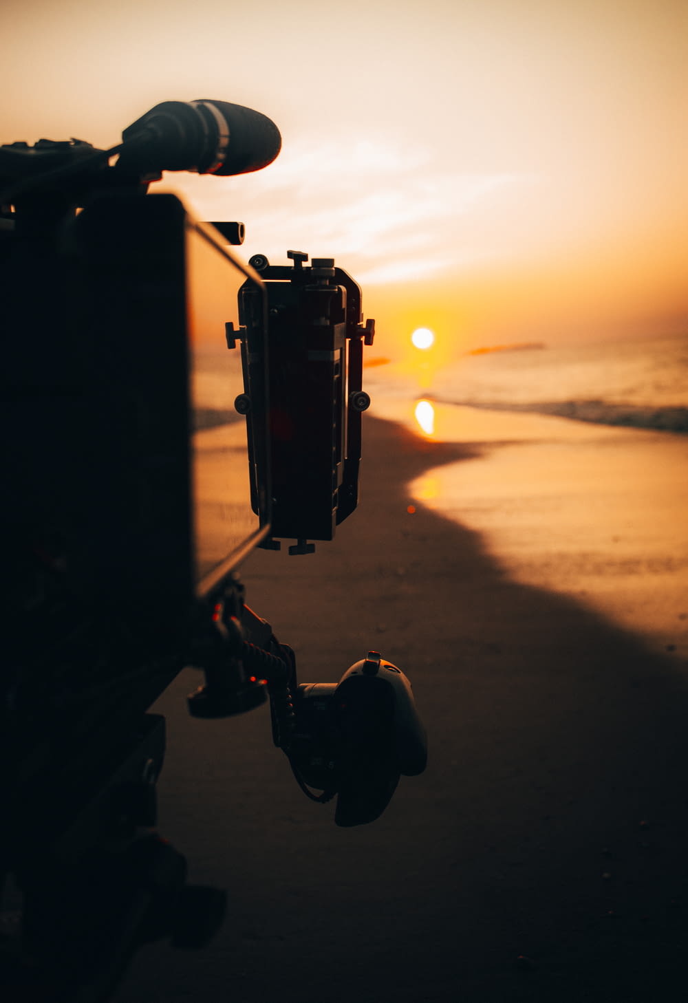 person holding camera during sunset