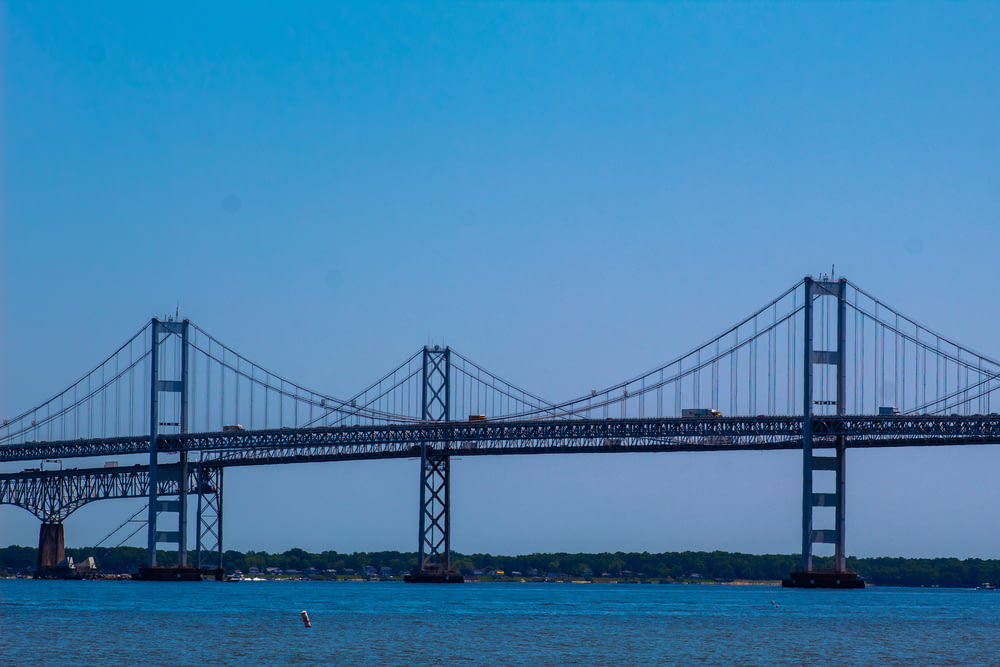 ponte preta sobre o mar azul sob o céu azul durante o dia
