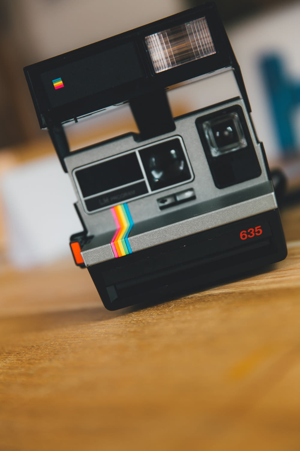 black polaroid instant camera on brown wooden table