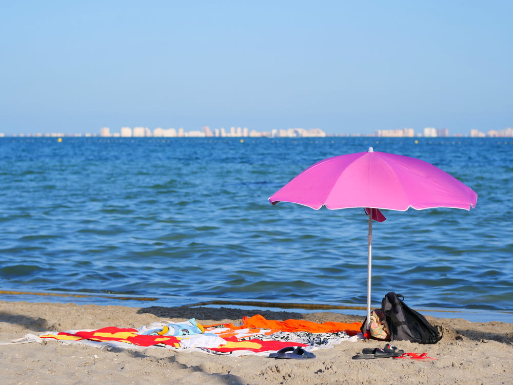 pink umbrella on beach during daytime