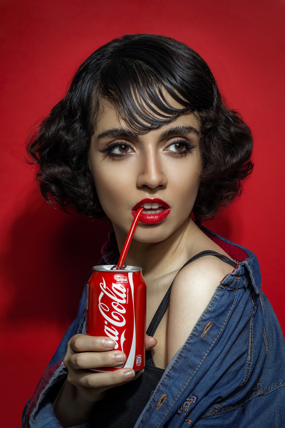 コカ・コーラ缶を手にした青いタンクトップの女性