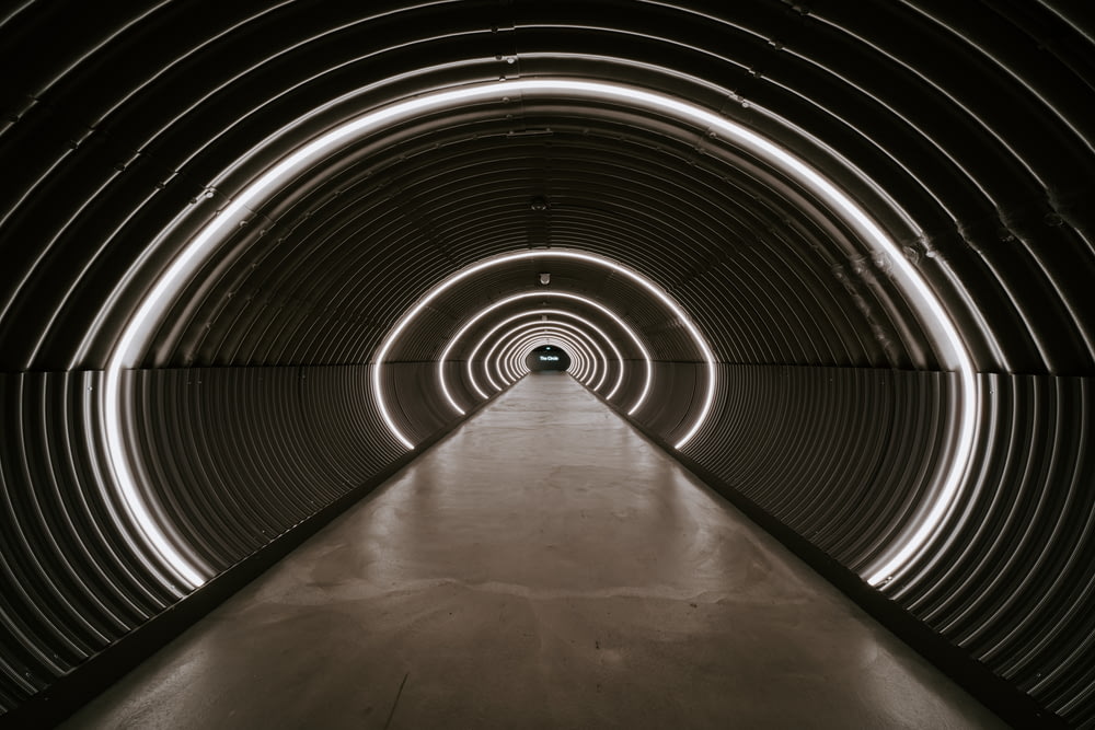 gray tunnel with light turned on during daytime