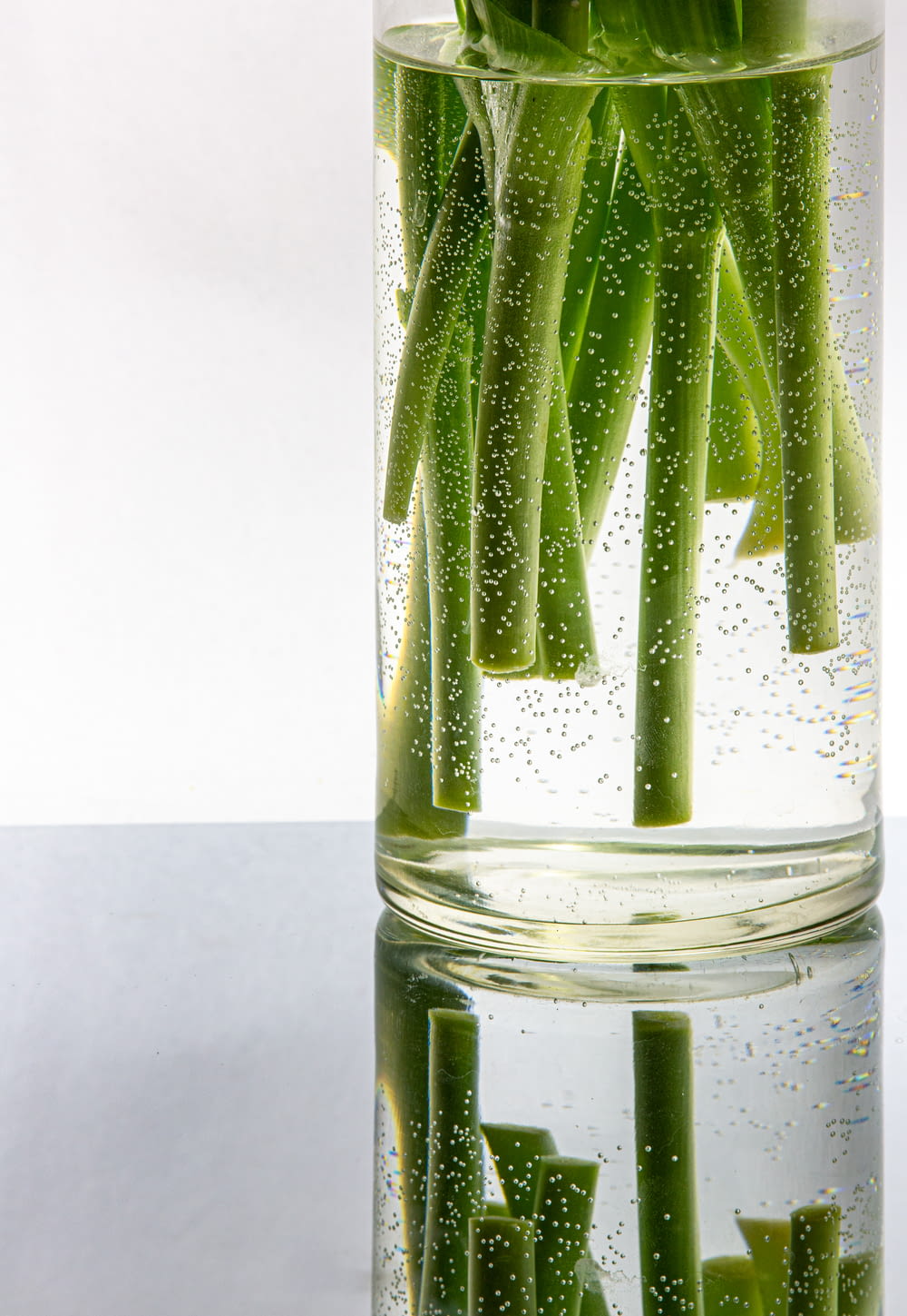 clear drinking glass with water and green leaves