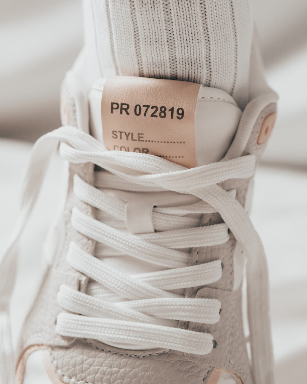 a pair of white sneakers with a label on them