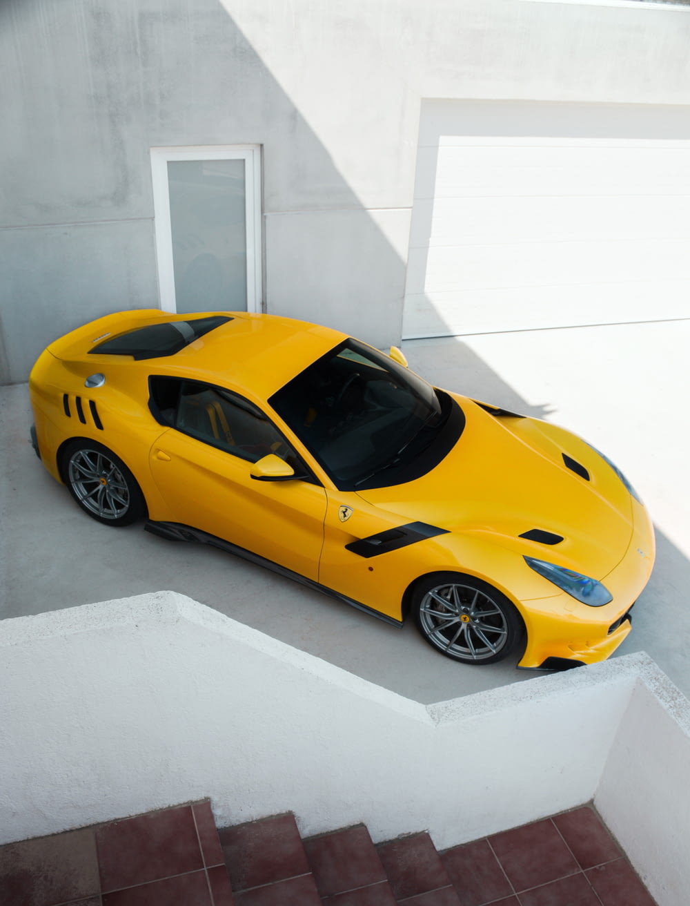 a yellow sports car is parked on a ledge
