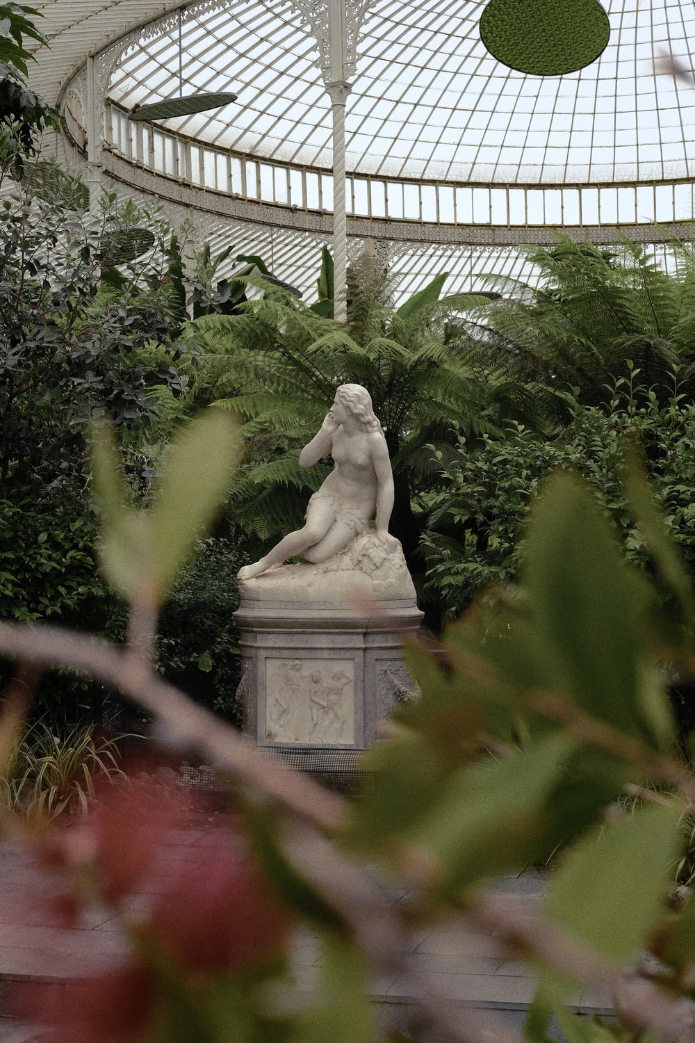 a statue of a woman in a greenhouse