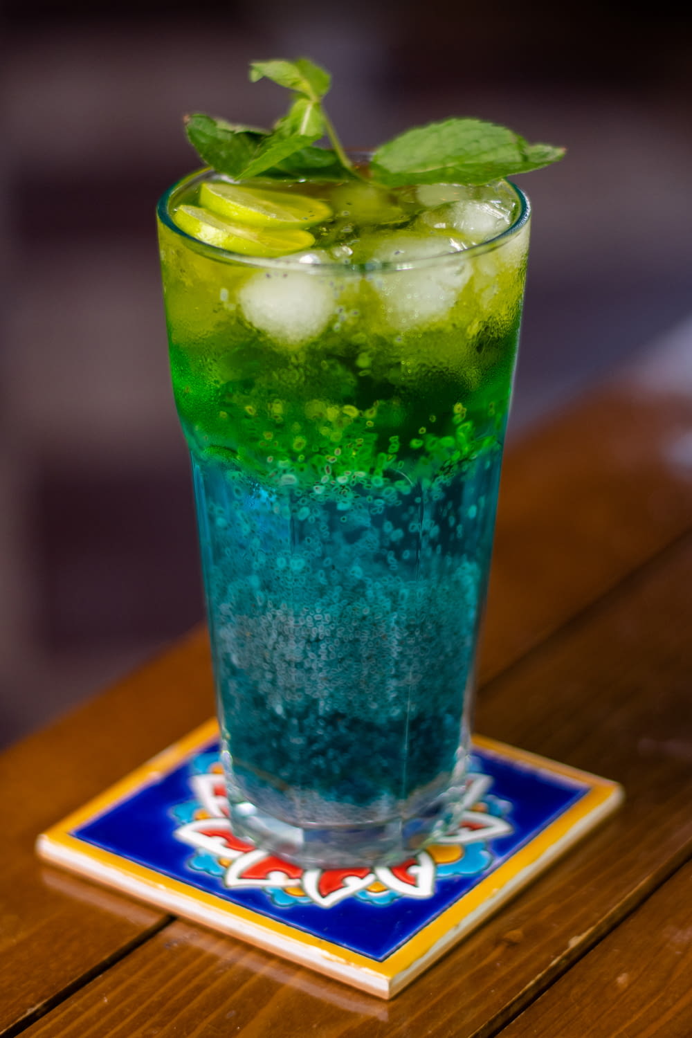 a tall glass filled with green and blue liquid