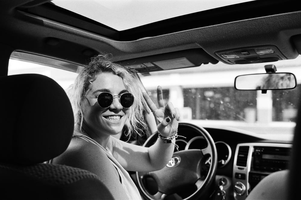 grayscale photo of woman driving car
