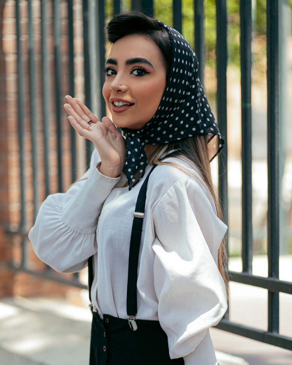 Mujer con camisa blanca de manga larga y hiyab de lunares blanco y negro