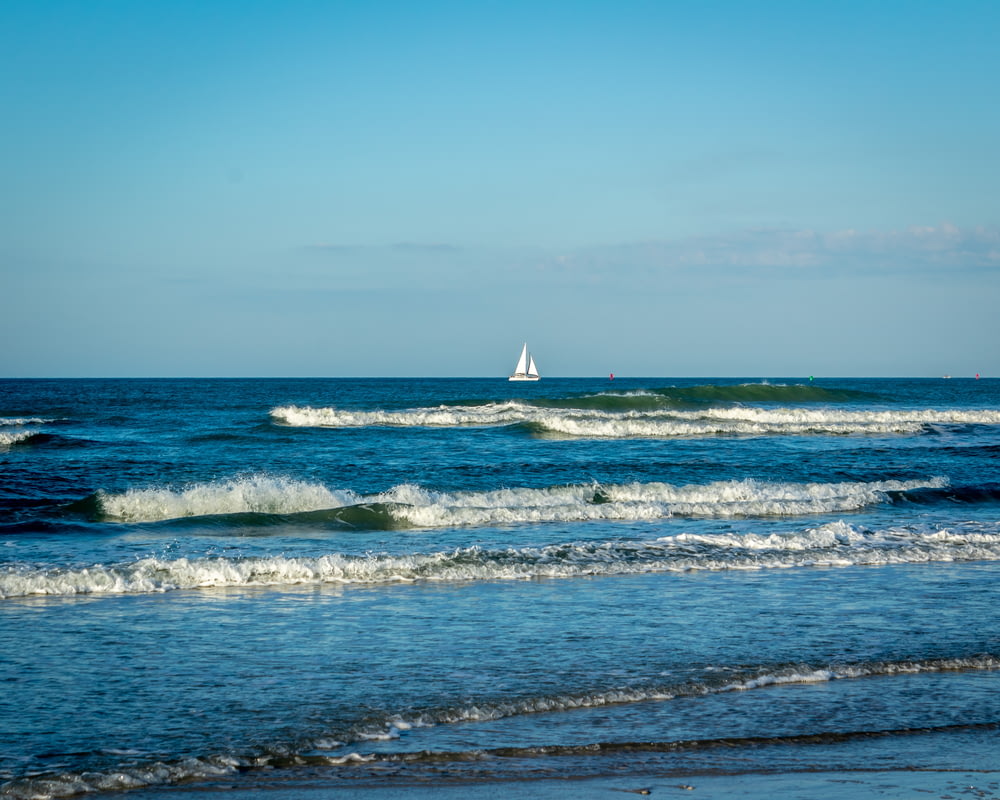 a sailboat in the distance on the ocean