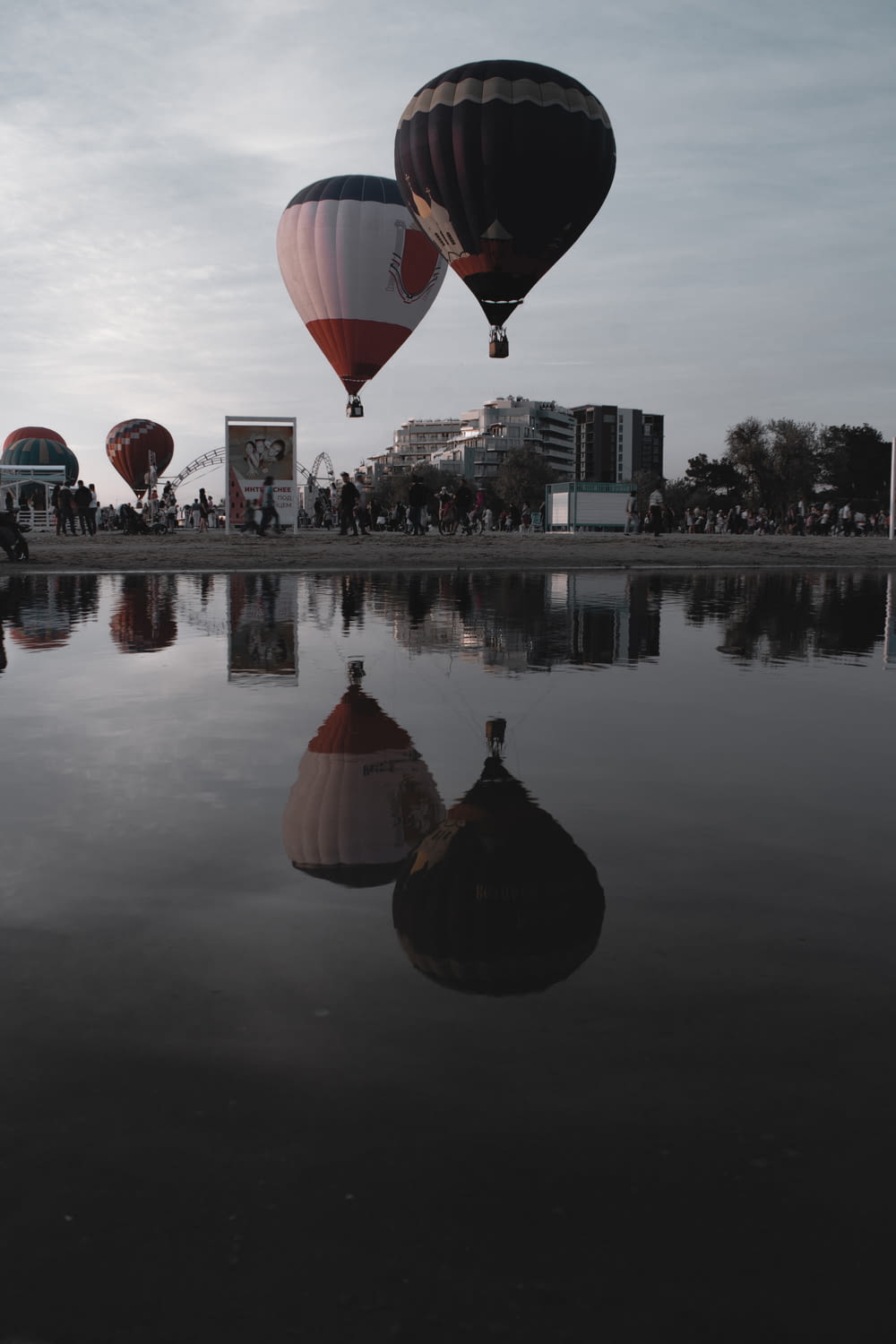 um grupo de balões de ar quente voando sobre um lago