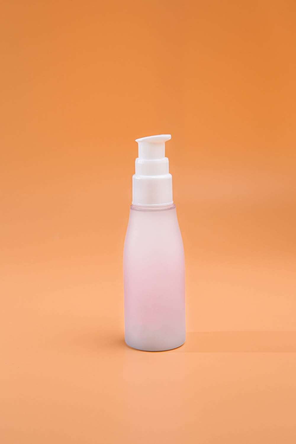 a bottle of lotion on an orange background