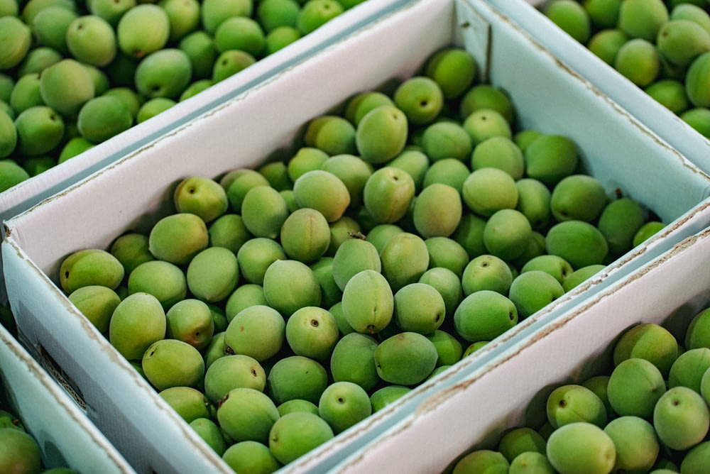 green fruits in white plastic crate