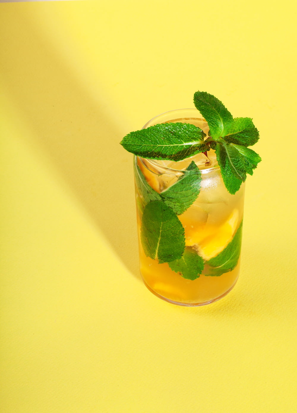 a glass of lemonade and mint on a yellow background