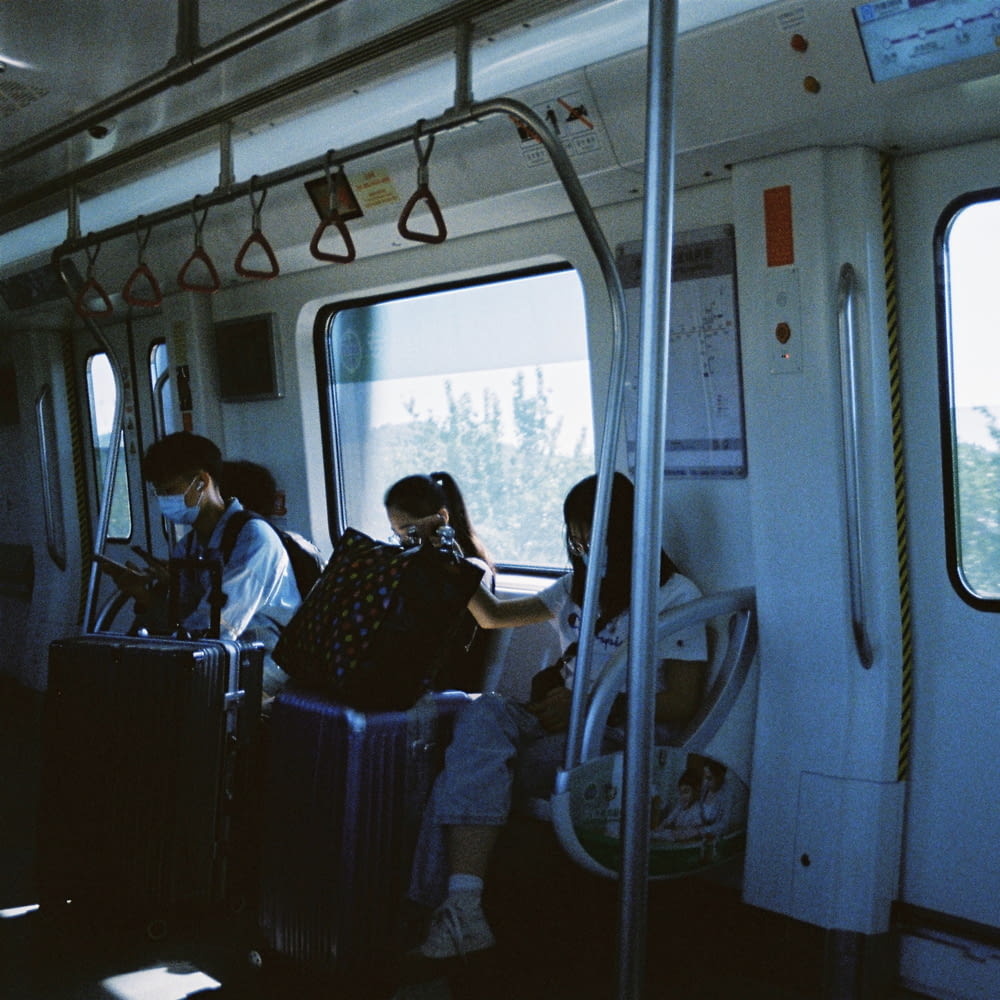 a group of people sitting on a train next to each other