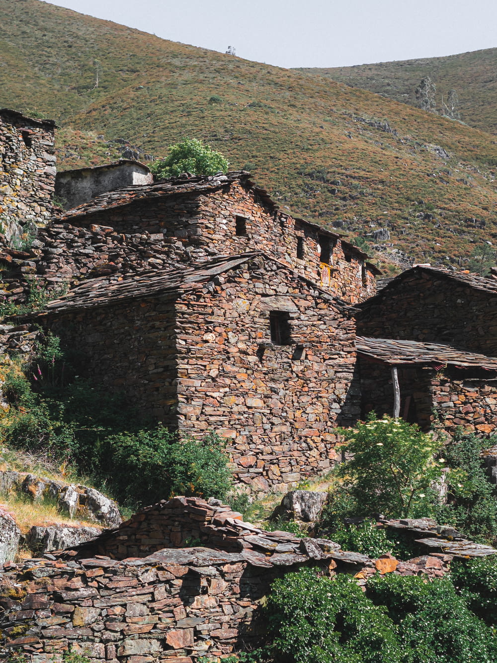 an old stone building with a mountain in the background