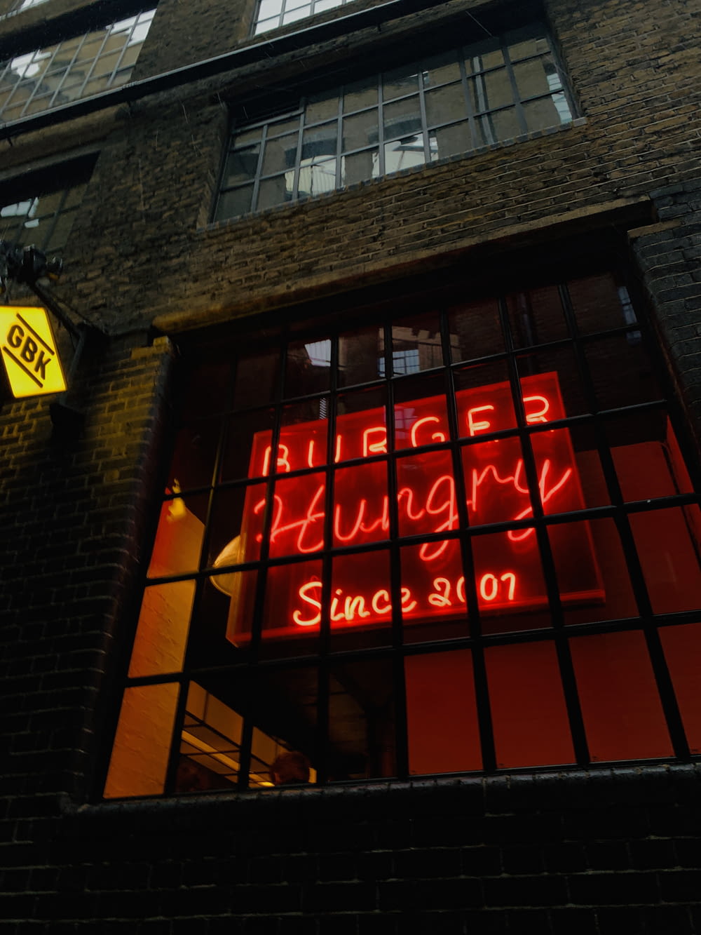 a large brick building with a neon sign in the window