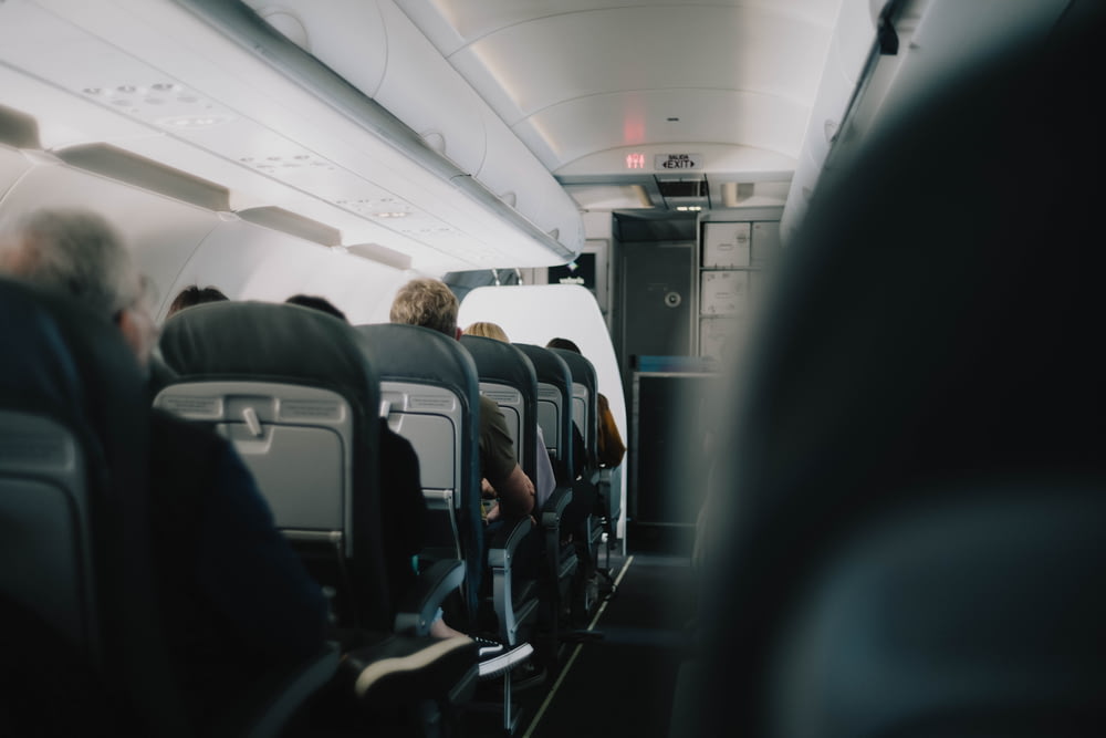 a group of people sitting on seats on an airplane