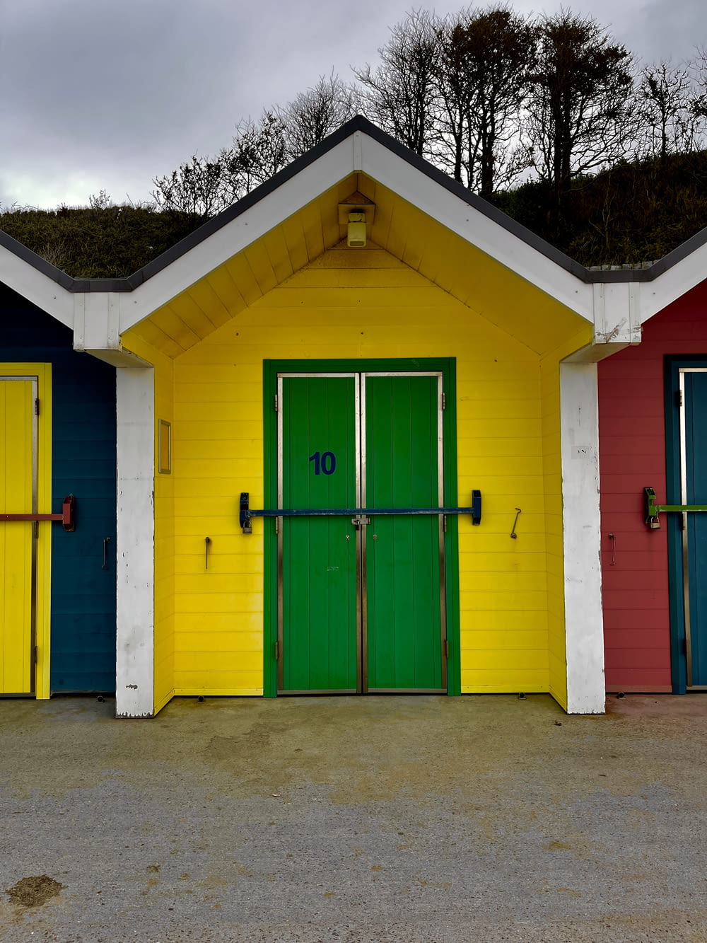 Una fila de puertas de garaje de colores brillantes frente a un edificio