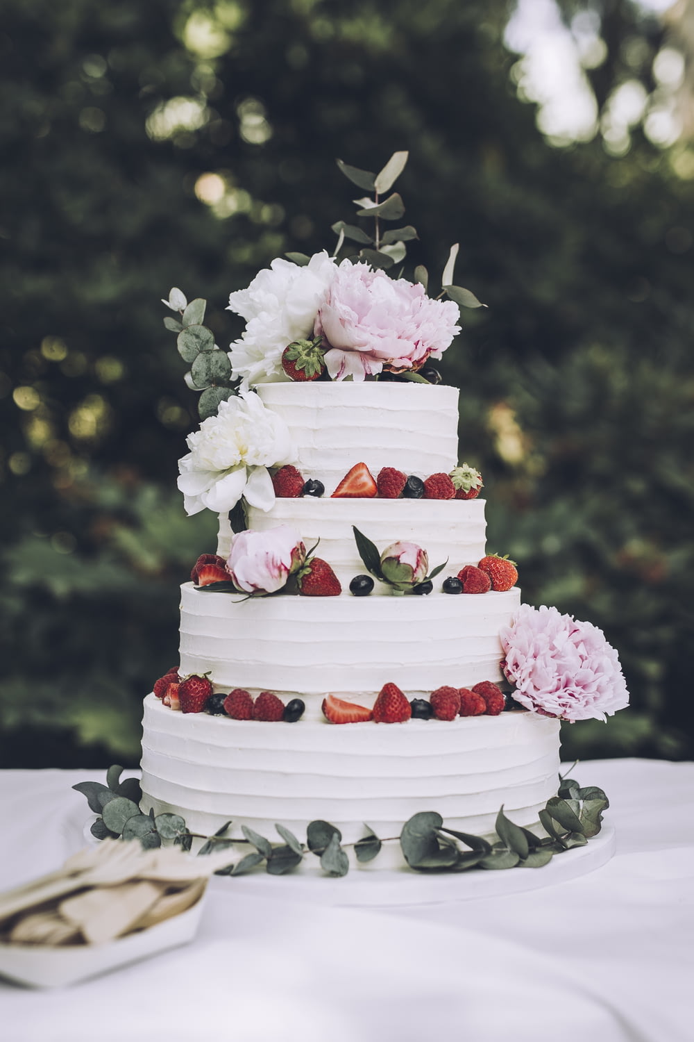 a white wedding cake with fresh strawberries and flowers