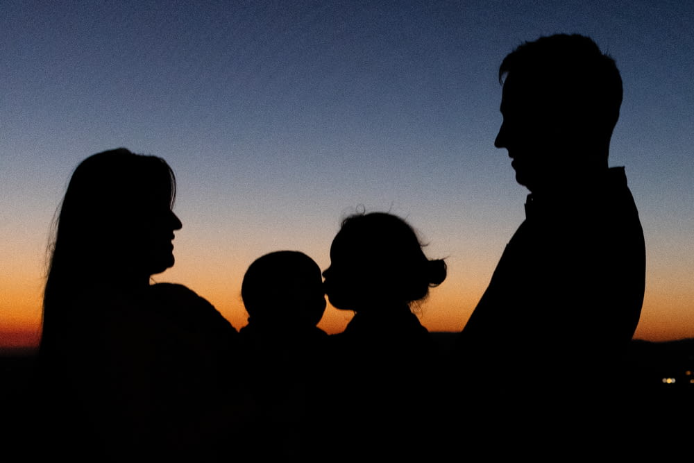 Silhouette von 2 Männern und Frauen bei Sonnenuntergang
