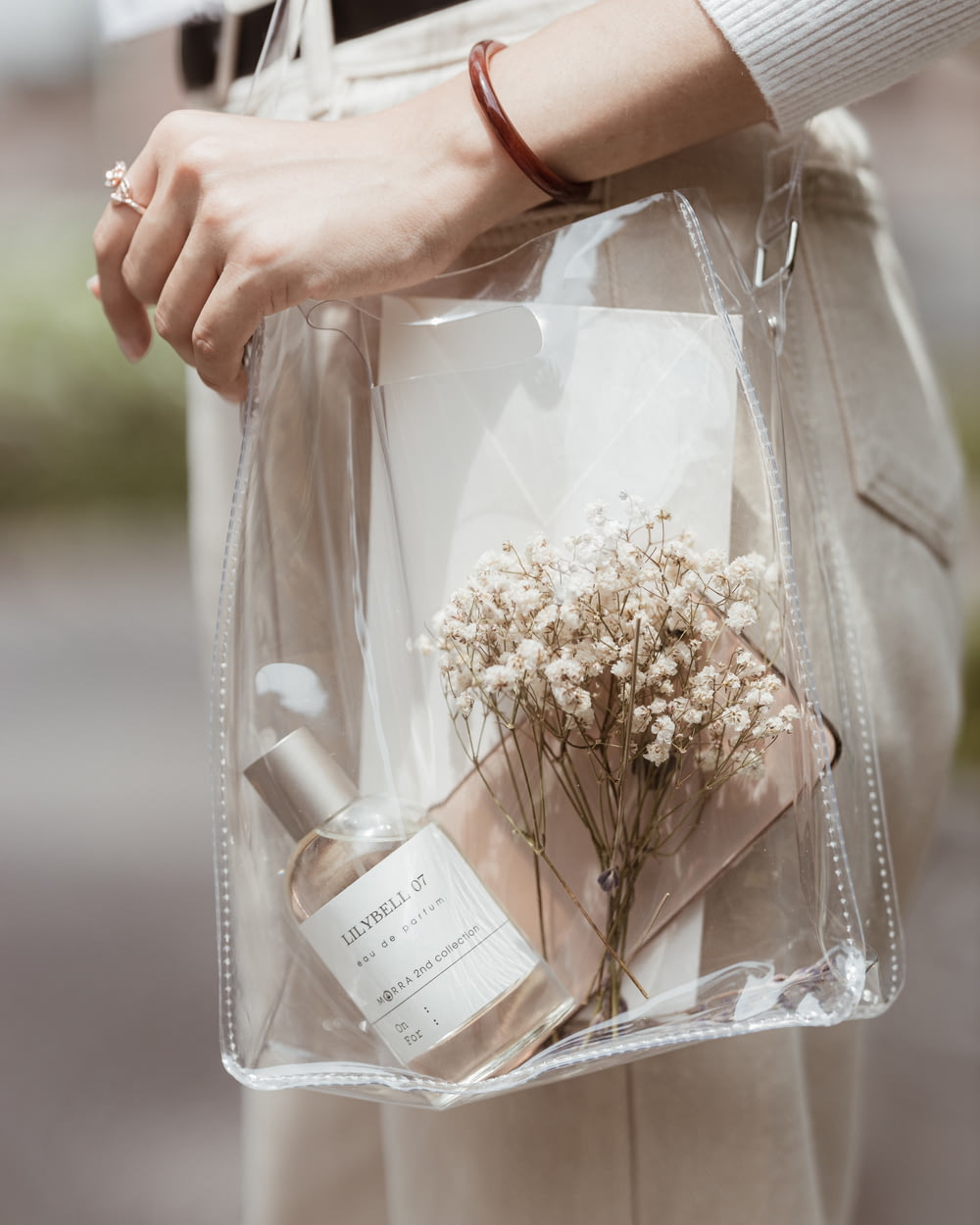 a person holding a clear bag with flowers in it
