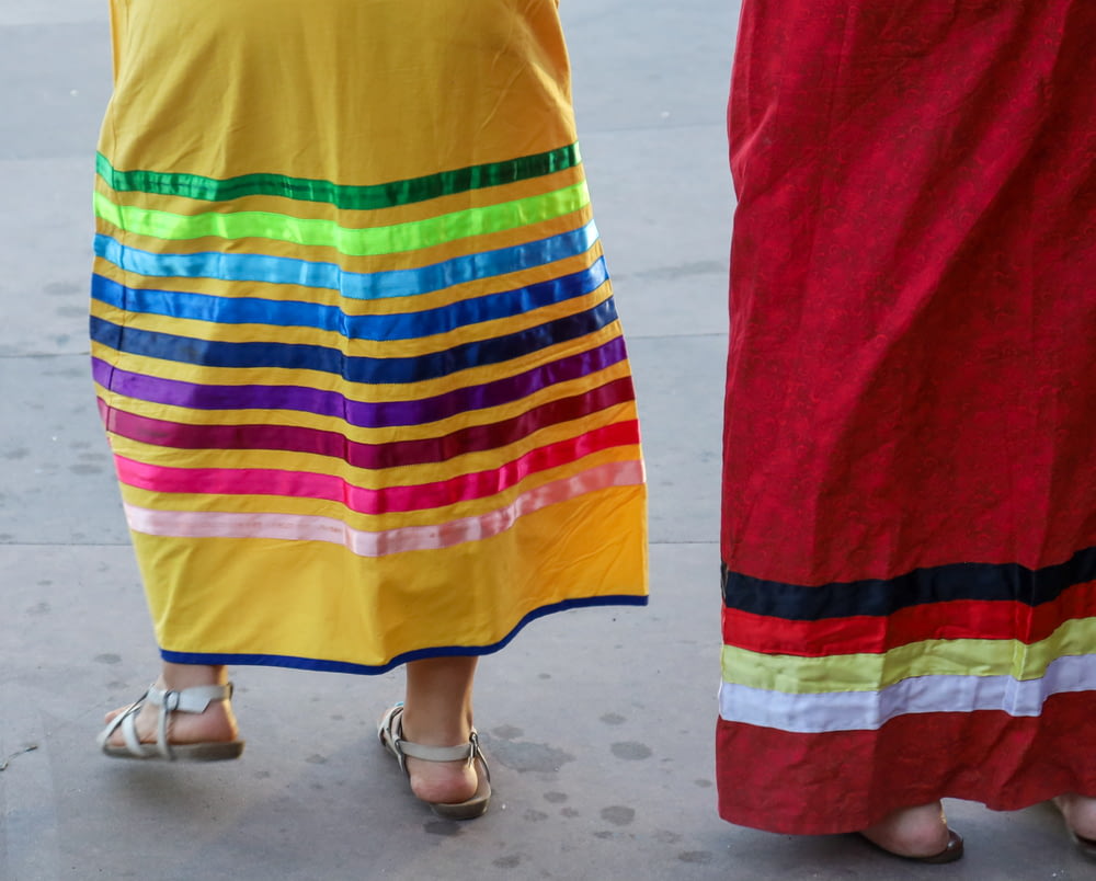 person in red yellow blue and green skirt
