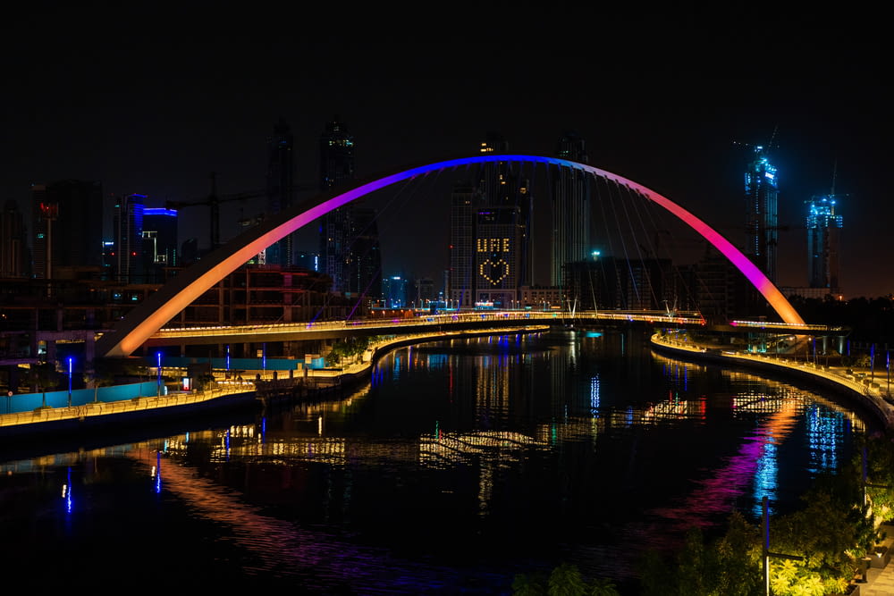 lighted bridge over body of water during nighttime