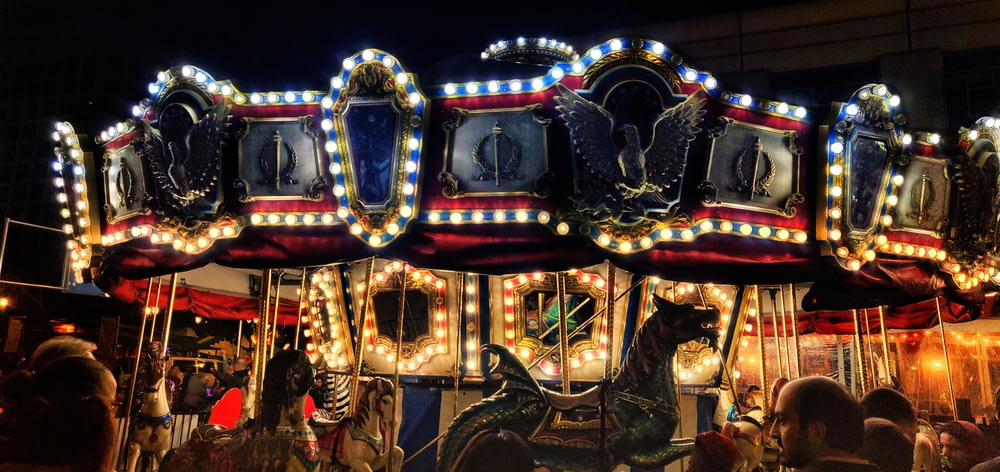 white and red carousel with people riding