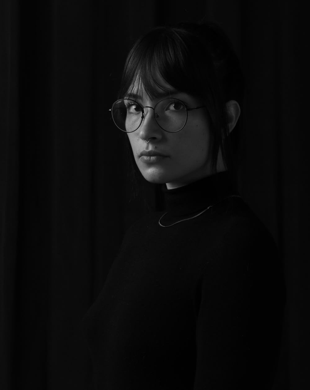 grayscale photo of woman wearing eyeglasses and turtle neck sweater