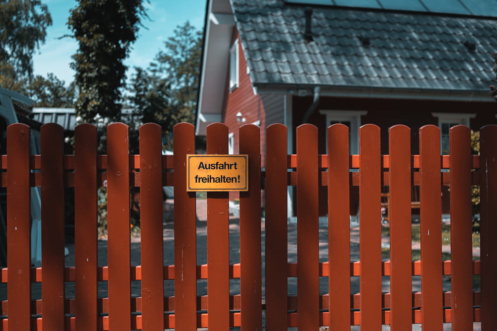 red wooden fence with no smoking sign