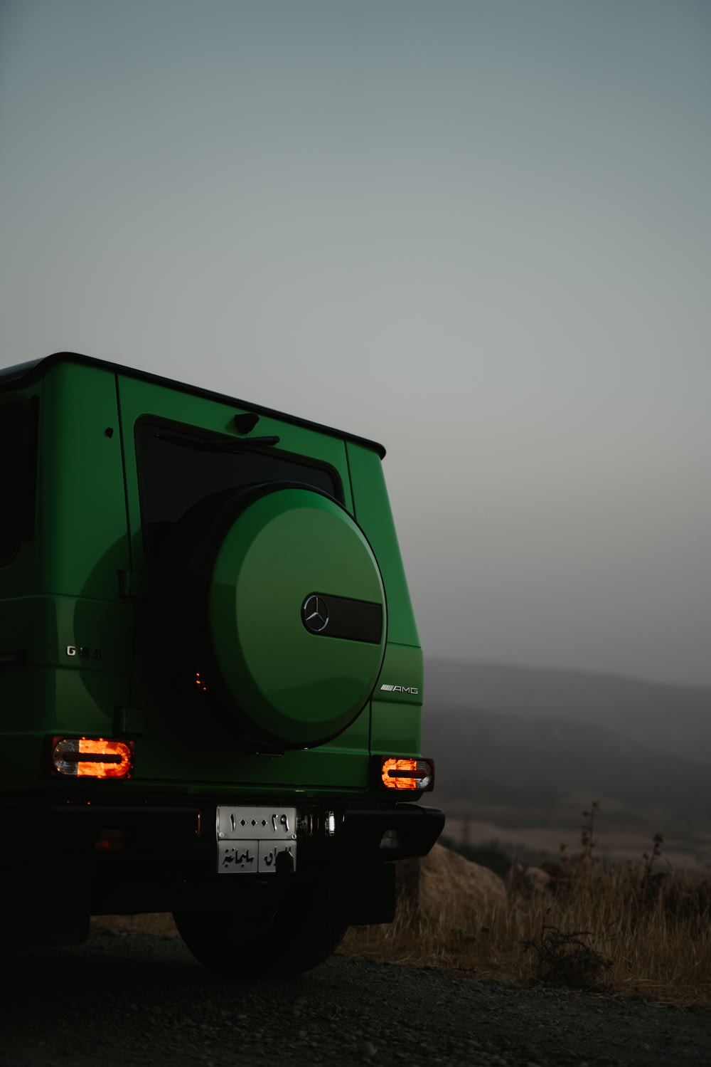 日中の道路を走る緑と黒のトラック