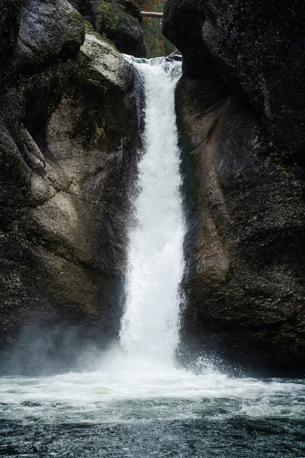 waterfalls between brown rocky mountain during daytime