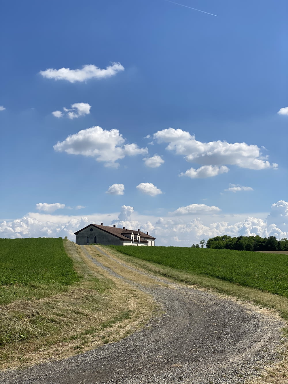 brown house on green grass field under blue sky and white clouds during daytime