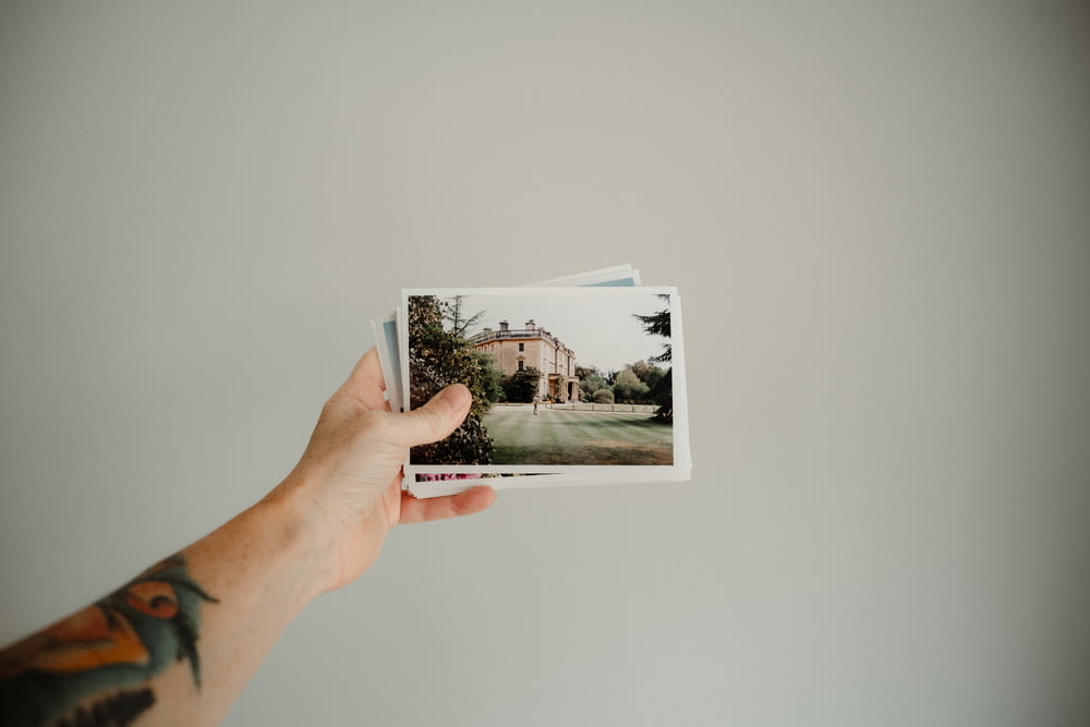 person holding photo of house