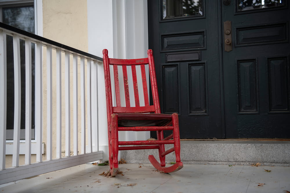 red wooden rocking chair near white wooden wall