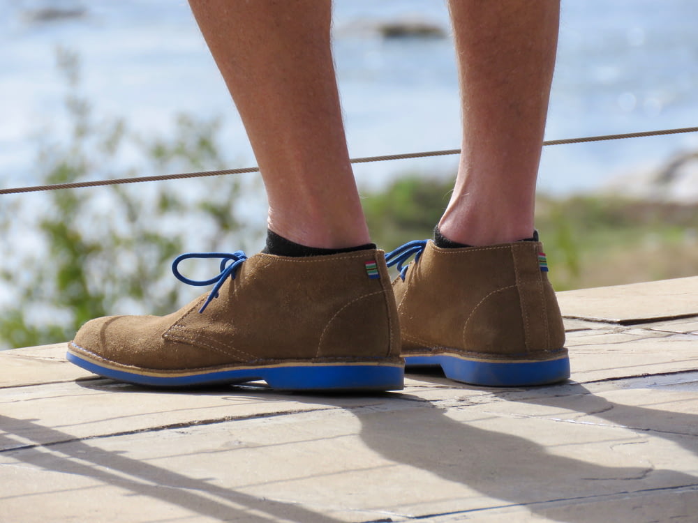 person wearing blue and brown leather shoes